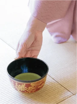 写真:抹茶の茶碗を畳に置く手元