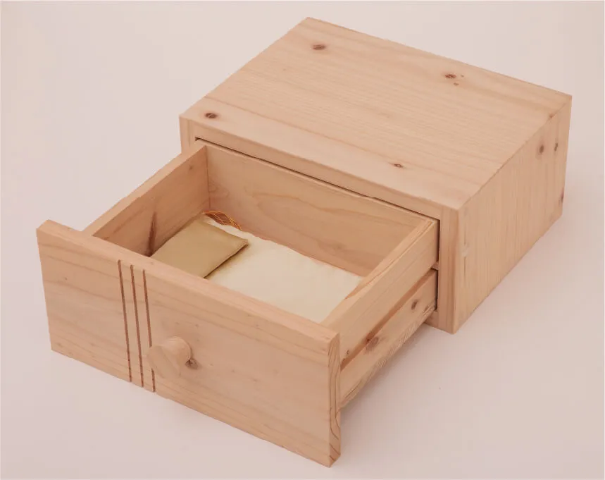木製引き出しの中に、柔らかい素材の布とアクセサリーが収納されている様子。