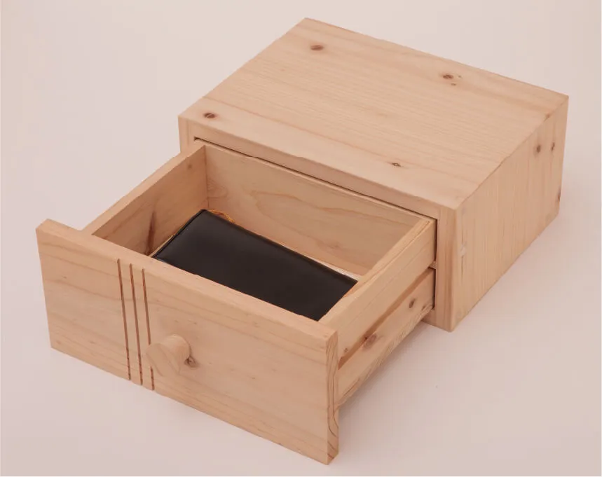 木製引き出しに黒い財布が収められ、シンプルで実用的な収納例です。